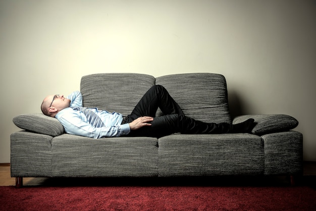 Premium Photo | Businessman lying on a sofa