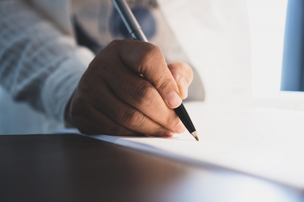 Premium Photo | Businessman manager hands holding pen for checking and ...