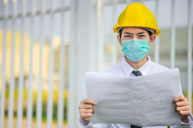 Download Premium Photo Businessman Manager Use Face Mask Yellow Hard Hat Holding Blueprint Work Building Construction PSD Mockup Templates