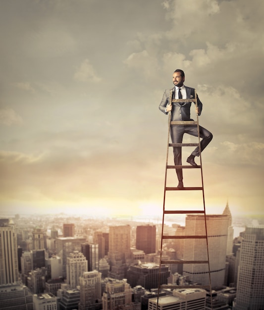 Businessman on the top of a ladder Premium Photo
