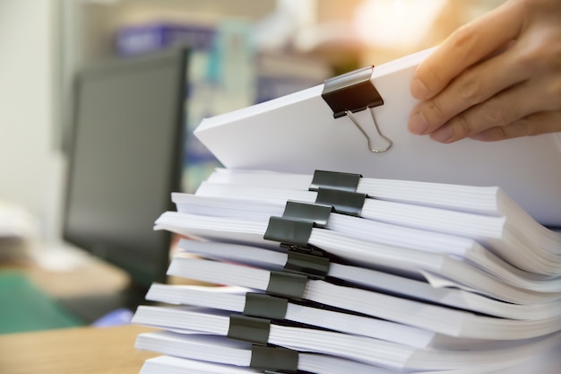 Premium Photo Businessman Working In Stacks Paper For Searching Information On Work Desk Office