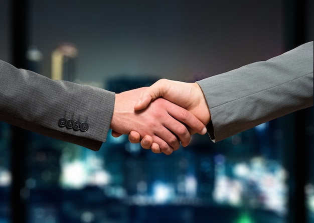 premium-photo-businessmen-shaking-their-hands-at-night