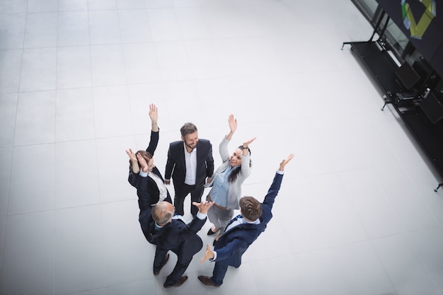 Businesspeople standing with hands raised Free Photo