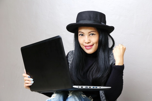 Businesswoman, charming beautiful tan skin asian business chic woman hand work on laptop and success hand up Premium Photo