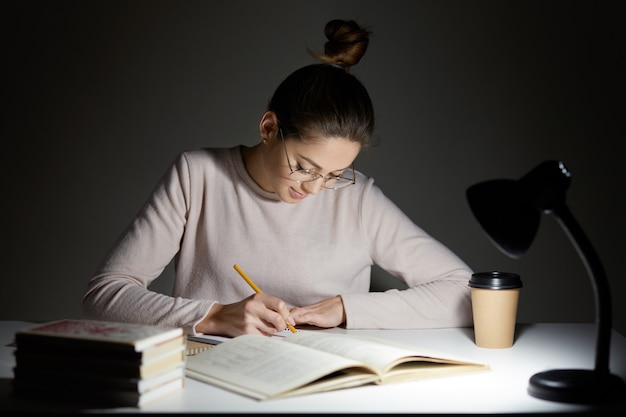 Busy freelancer rewrites infrormation into notepad Free Photo