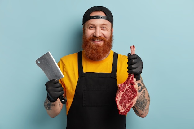 Free Photo | Butcher man with ginger beard holding meat