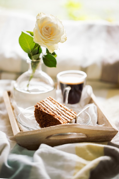 Premium Photo | Cake with coffee and flower in tray on bed