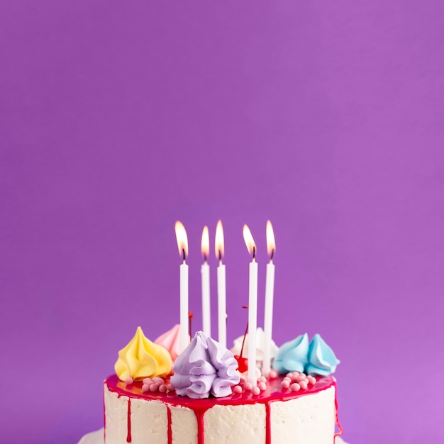 Cake With Lit Candles On Purple Background Free Photo