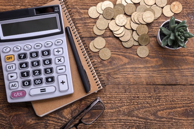 Premium Photo | Calculator keypad, gold coins, pen and notebook on a ...