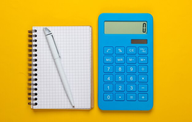 Premium Photo | Calculator with notebook on yellow background ...