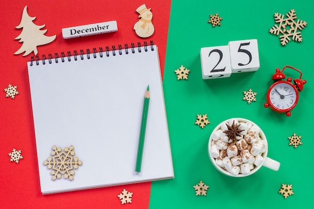 Calendar december 25th cup cocoa and marshmallow, empty open notepad Premium Photo