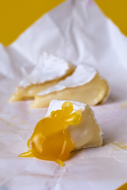 白い紙に蜂蜜とカマンベールチーズ プレミアム写真