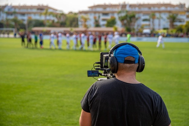 サッカーの試合でビデオを撮影するカメラを持つカメラマン プレミアム写真