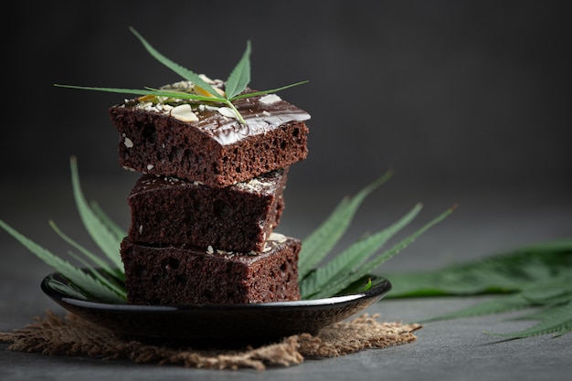Cannabis brownies and cannabis leaves put on black plate Free Photo