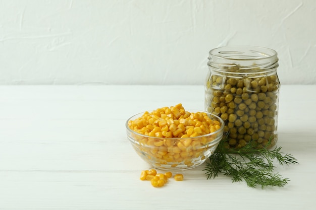  Canned peas and corn on white wooden table Premium Photo