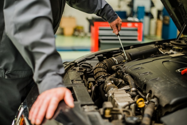 Premium Photo | Car mechanic checking engine. auto repair service.