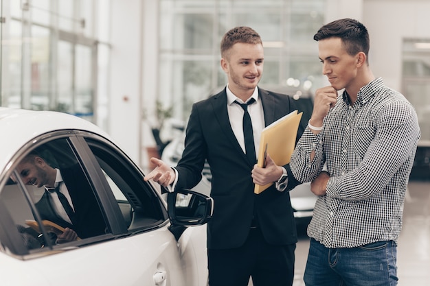 Car salesman working with a customer at the dealership Premium Photo