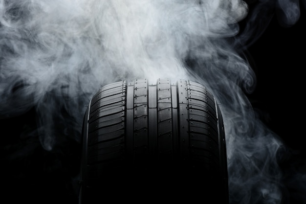 Premium Photo | Car tire and smoke on black