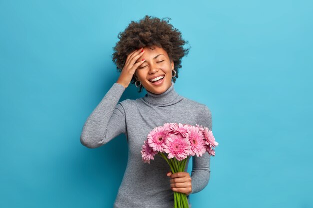 Free Photo Carefree Optimistic Dark Skinned Ethnic Woman Holds