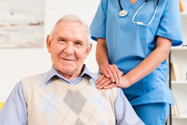 Caregiver holding old man's shoulder Free Photo