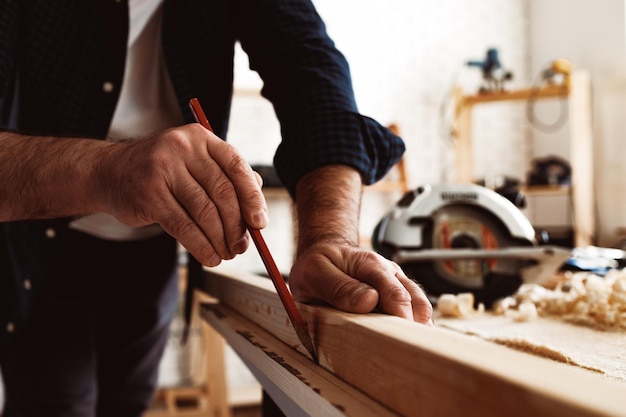 Free Photo | Carpenter makes pencil marks on a wood plank