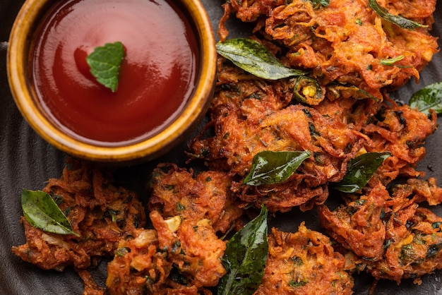 Premium Photo | Carrot fritters or gajar ke pakore or pakode or bajji ...