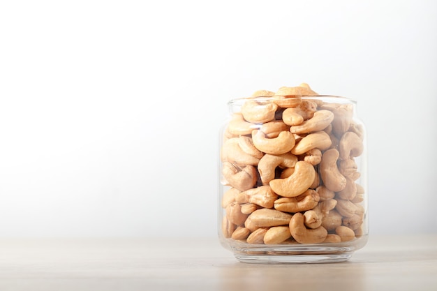 Premium Photo | Cashew nuts in glass bottles placed on a wooden floor ...