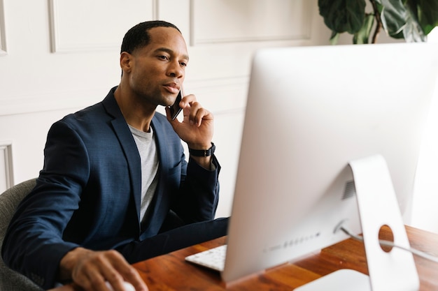 Premium Photo | Casual businessman talking on a phone while working in ...