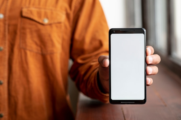 Casual man showing his mobile phone Free Photo