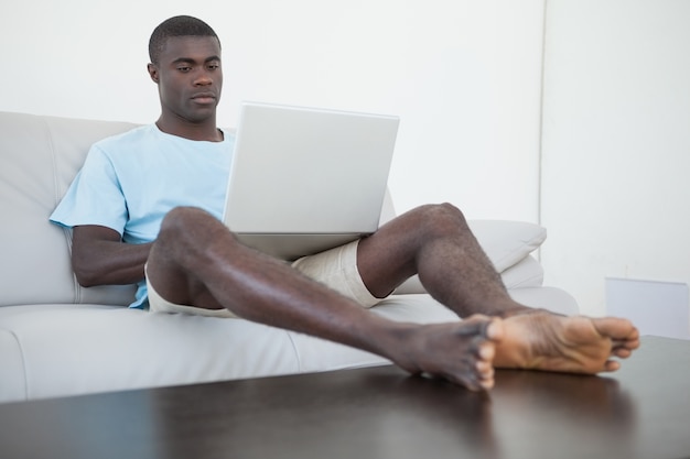 Premium Photo Casual Man Sitting On Sofa Using Laptop With Feet Up   Casual Man Sitting Sofa Using Laptop With Feet Up 13339 140589 