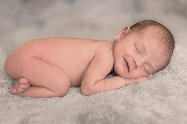Caucasian baby girl sleeping and smiling on a blanket Premium Photo