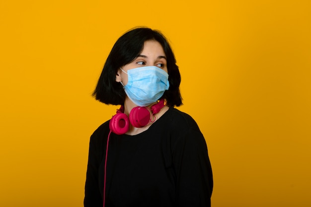 Premium Photo | The caucasian girl in blue colored protective mask.  portrait shot over yellow background.