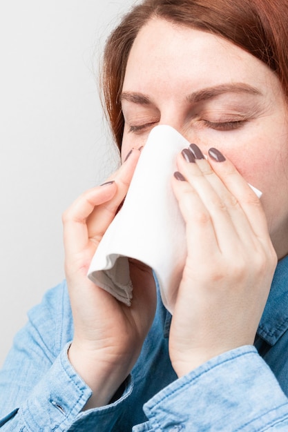 Premium Photo | Caucasian ill upset woman blow their nose in a napkin ...