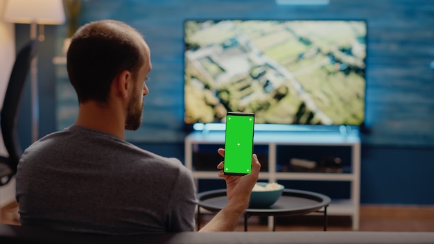 Premium Photo | Caucasian man vertically holding smartphone with green ...