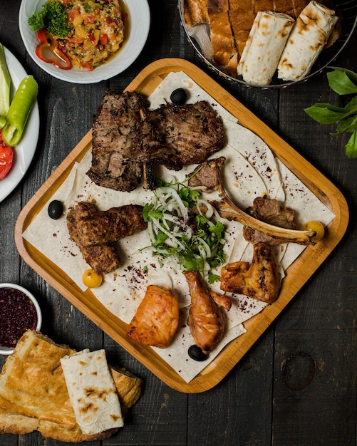 Caucasian meat kebab with herbal onion salad inside wooden platter. Free Photo