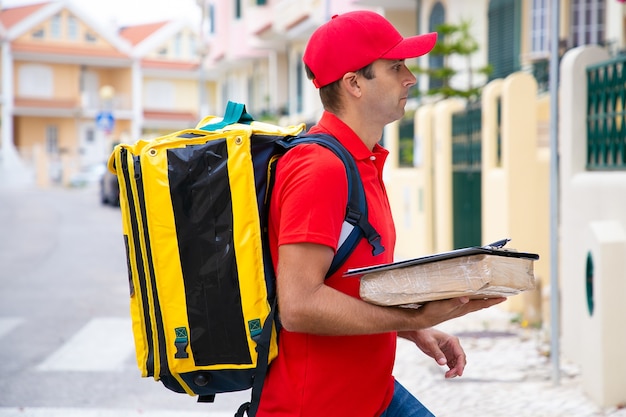 Free Photo | Caucasian postman holding parcel and delivering order ...