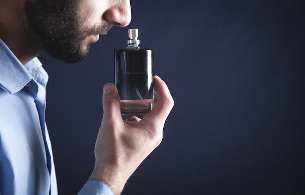 Premium Photo | Caucasian young man smelling perfume.