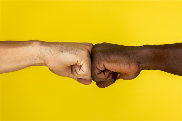 握りこぶしに握りしめられるヨーロッパとアフリカ系アメリカ人の手 無料の写真