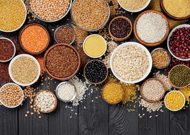 Cereals, grains, seeds and groats black wooden table Premium Photo