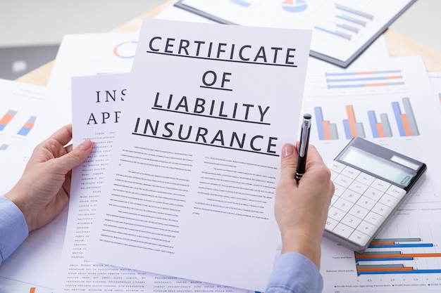 Certificat of liability insurance concept, documents on the desktop Premium Photo