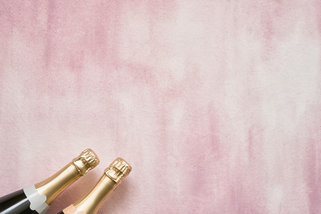 Champagne bottles on pink background. Photo | Premium Download