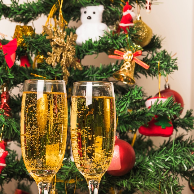 Free Photo | Champagne glasses in front of christmas tree