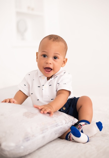 Premium Photo | Charming african american baby sitting on the bed