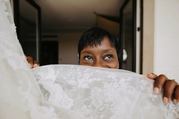 Charming African American Woman Looks Over Wedding Dress Free Photo