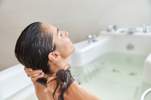 Premium Photo | Charming young woman washing hair while taking bath