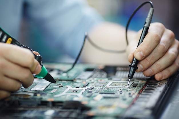 Checking current in laptop circuit board Free Photo
