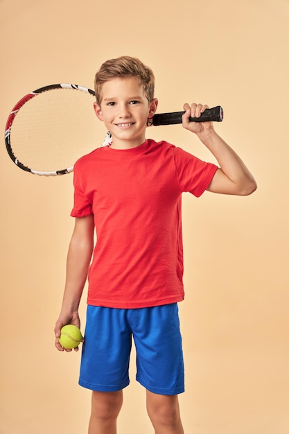 Premium Photo | Cheerful boy holding tennis racket and ball