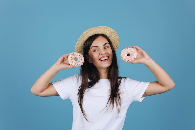 Free Photo Cheerful brunette has fun posing with delicious donuts picture