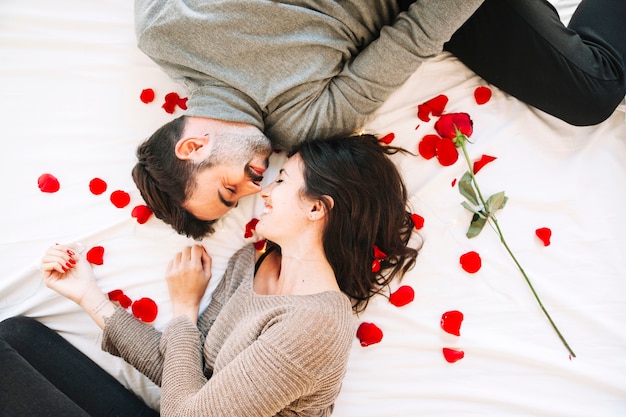 Cheerful couple touching noses on rose petals Free Photo Cheerful couple touching noses on rose petals Free Photo
