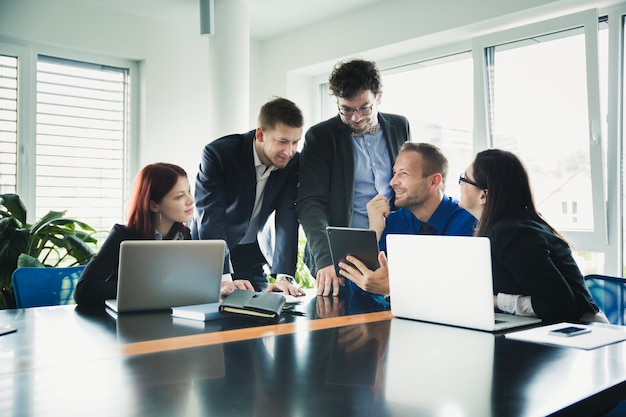 Cheerful coworkers at table with gadgets Free Photo